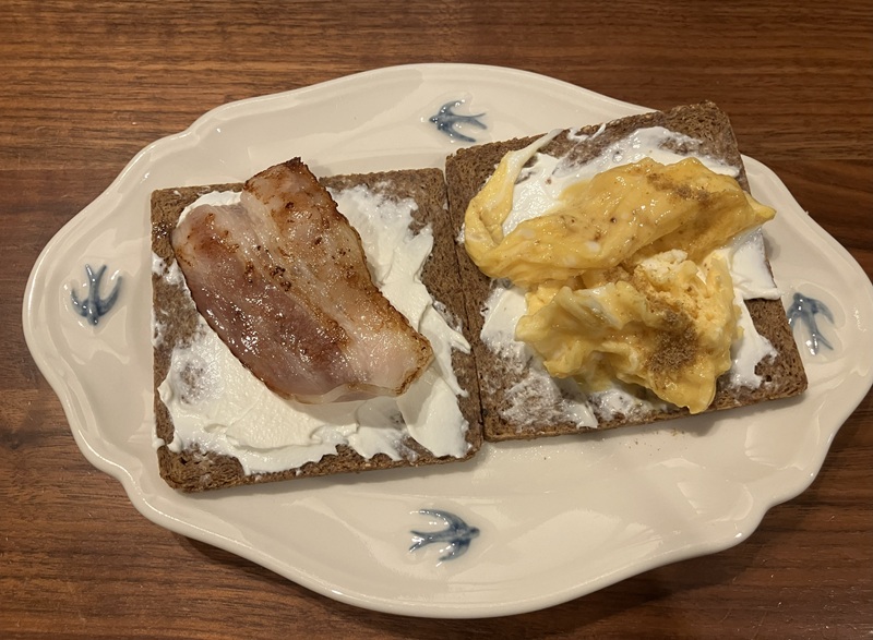 プンパニッケルにベーコンとスクランブルエッグのトッピング